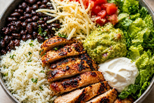 Frische Bowl mit Hähnchen, Reis, Gemüse, Bohnen und Guacamole